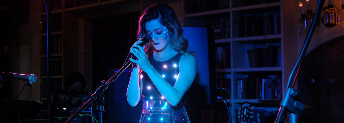 Anie Delgado performing in the Dark Power Bodysuit